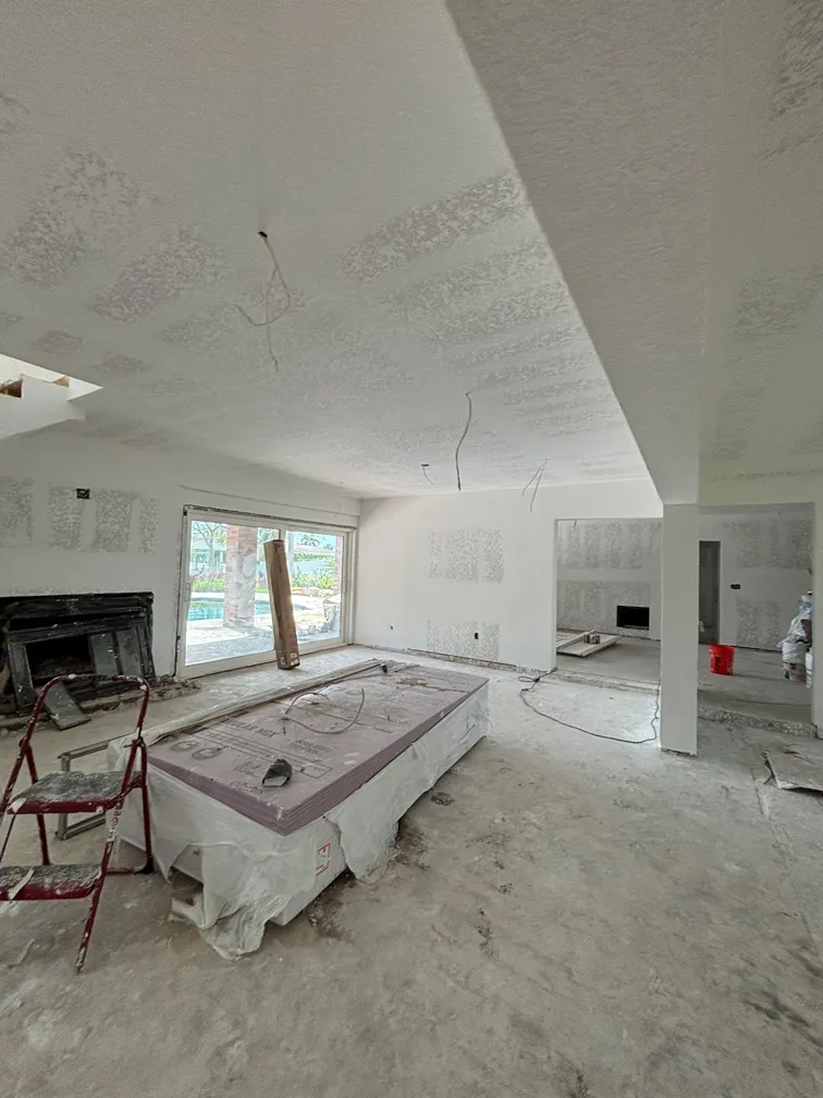 Living room under renovation with knockdown ceiling texture and drywall installation in progress – Tampa