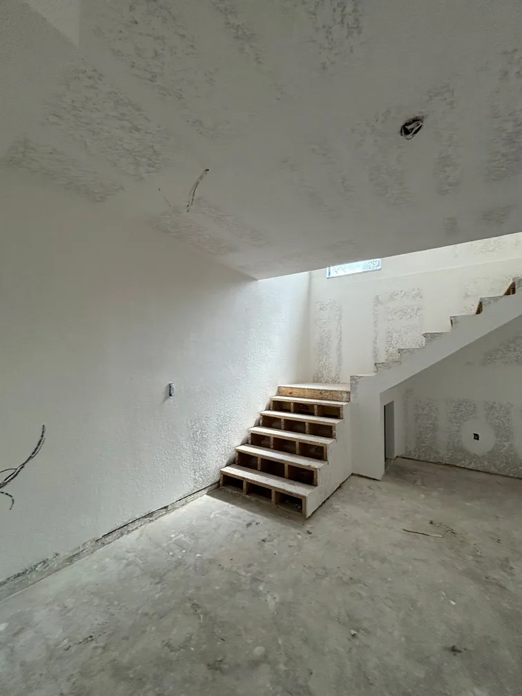 Staircase area with knockdown ceiling texture during drywall renovation in Tampa